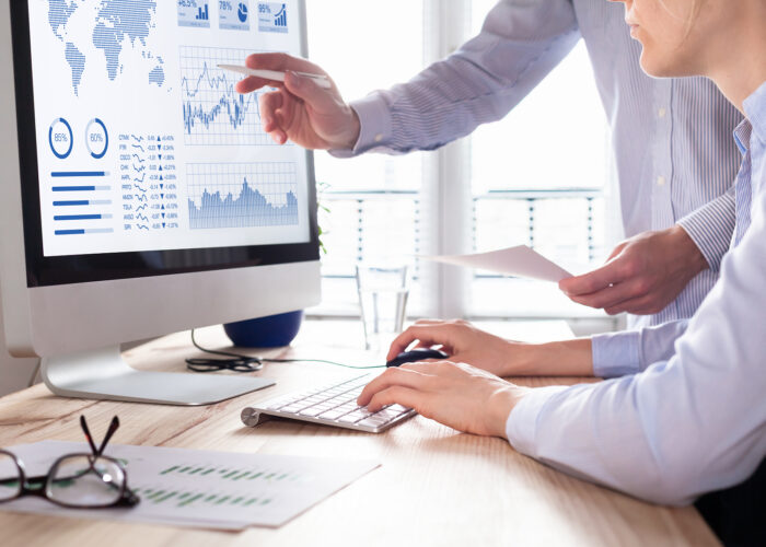Two people analyzing stock market investment strategy with key performance indicator on financial dashboard and business intelligence on computer