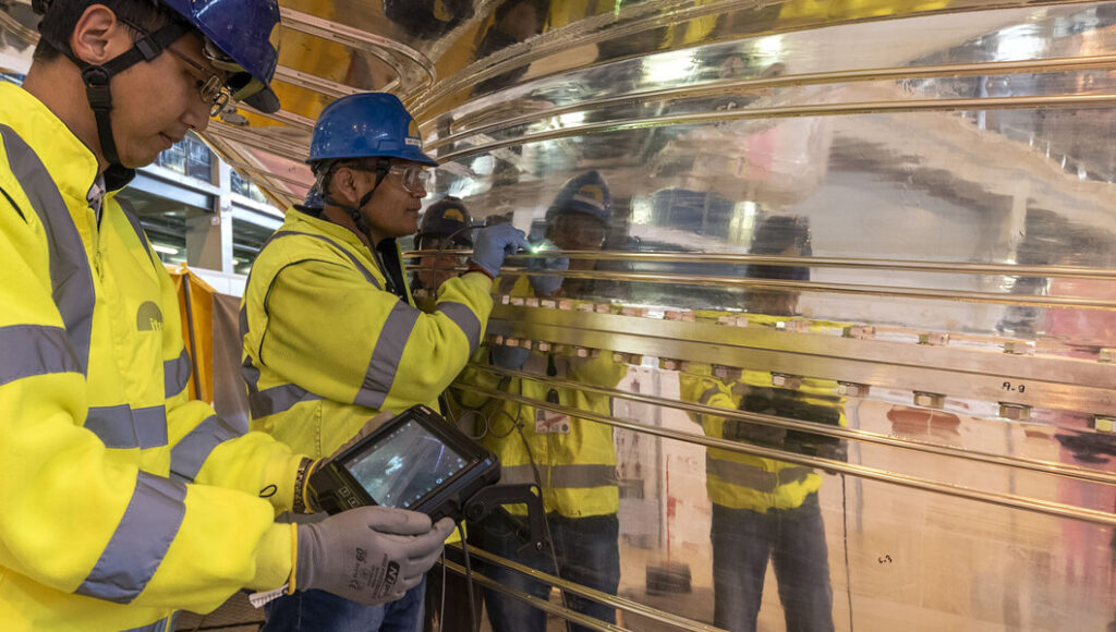 Technicians inspecting steel coils